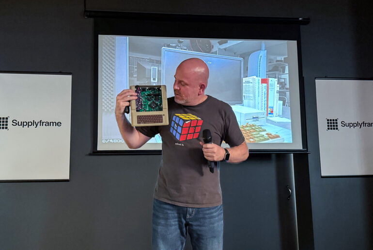 James (Bald Engineer) at Supercon 2023 on stage presenting Mega IIe